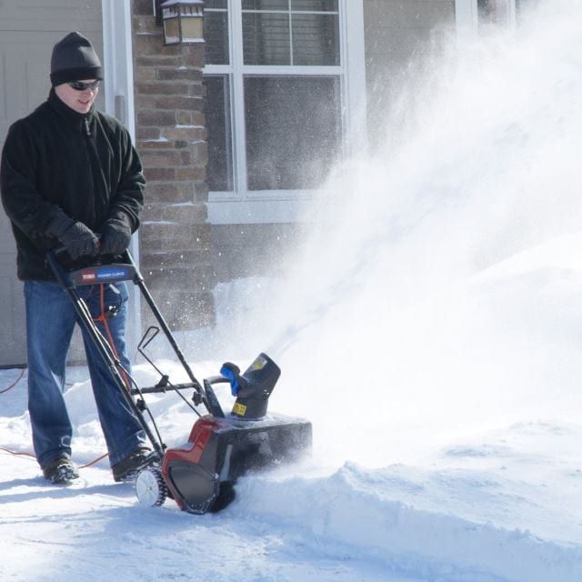 using snow thrower in winter corded electric snow blower in use