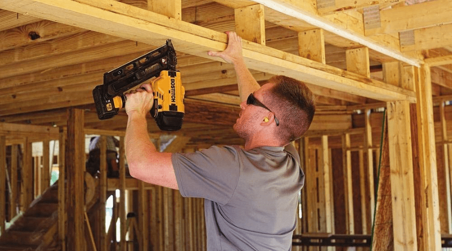 Man Using a Bostitch Cordless Nail Gun to Install the Wood Frame