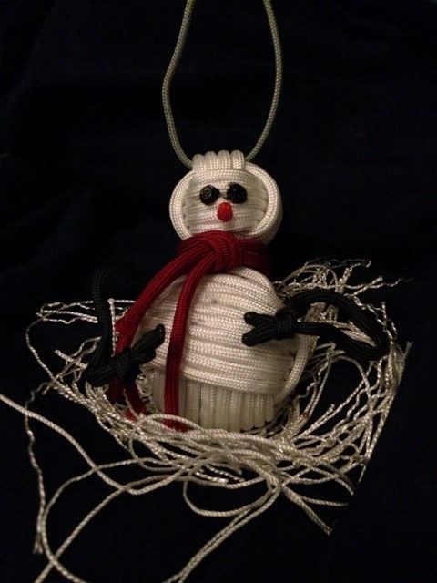 White cord strings formed as body of snowman and red cord string as scarf with two small eyes and red nose