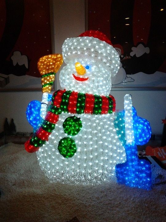 Christmas themed Snowman placed outside glowing in white, red, green, orange and blue lights