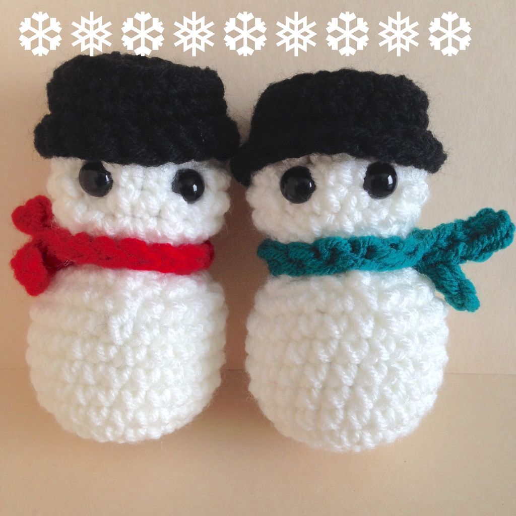 Two fluffy snowman adorned with hat and scarf with a bulgy black eyes attached