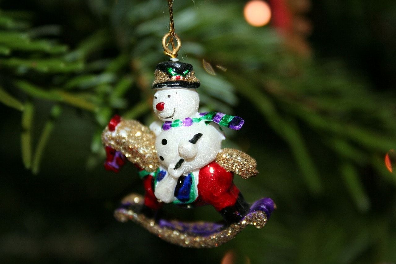 Christmas tree decoration snowman riding a little red horse glowing in glitters