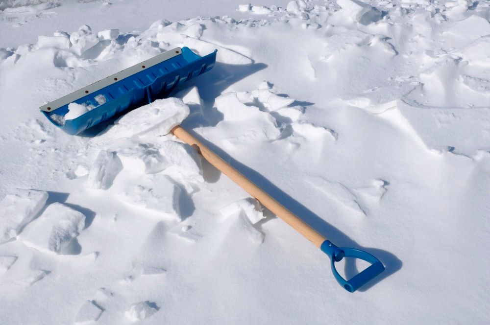 Blue snow shovel on the pearly white snow