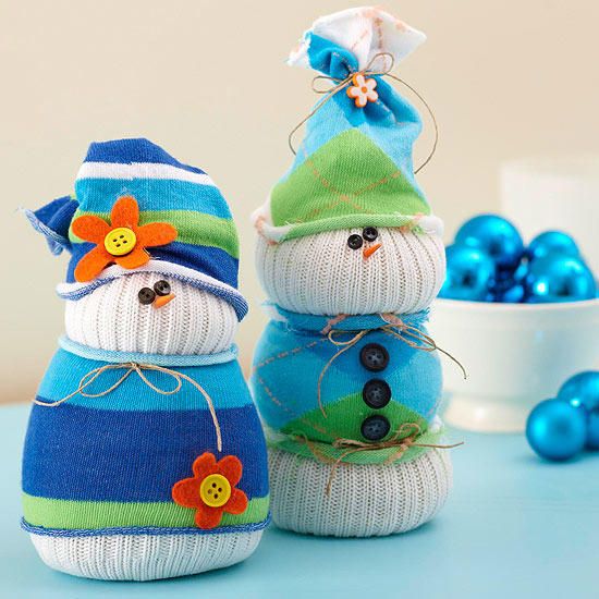 Snowman inspired made out of socks adorned with blue clothings and hat with buttons attached on its body and eyes as well