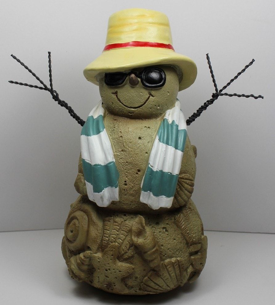 Stonemade snowman with several carved clams and shells on its bottom decorated with glasses, hat and a scarf attached with a wire twisted to form as an arm