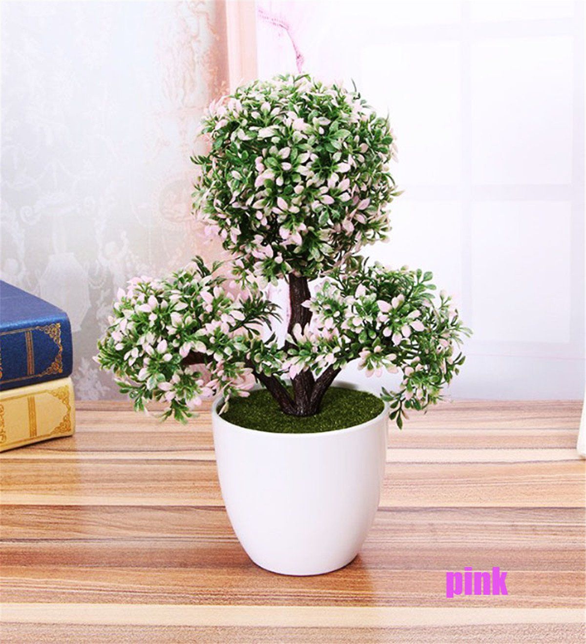 Round shaped leaves of indoor bonsai tree planted in a tall rounded white pot