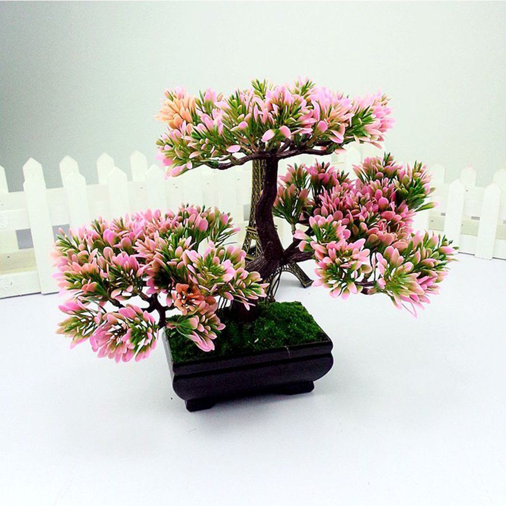 Pink flowering Indoor bonsai tree with white fence on the background and a miniature eiffel tower
