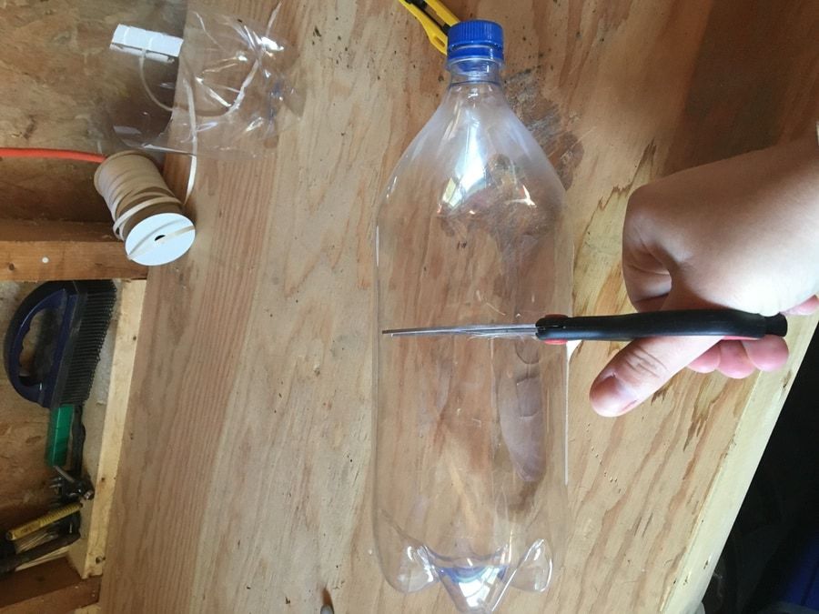 Plastic bottle cut half using a scissor.