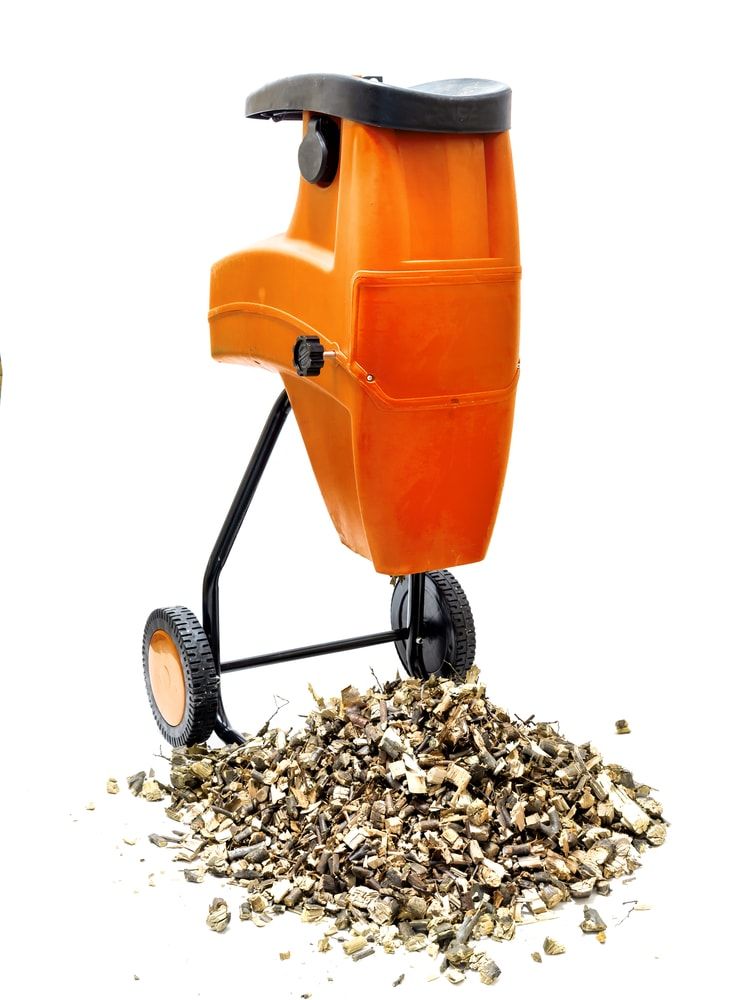 Electric wood shredder with wood chips used for garden mulching shot on white
