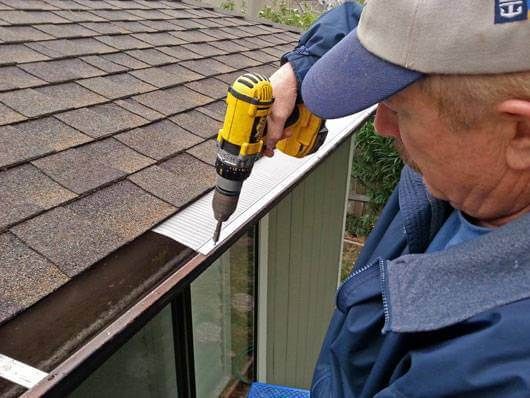 a person installing easyon gutter guard on the roof
