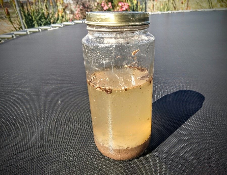 Soil and water mixture inside a glass jar
