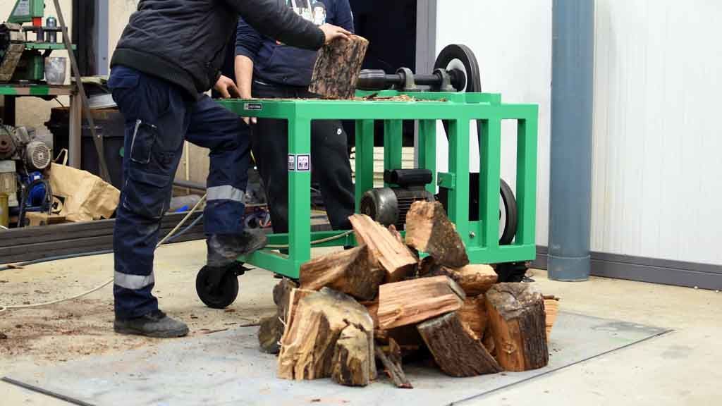 a man cutting a log using screw log splitter machine