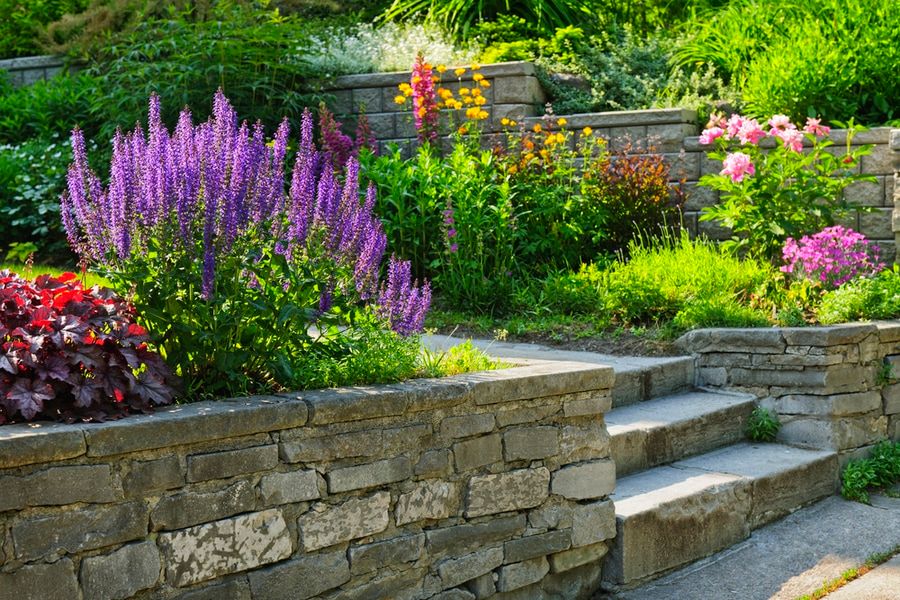 Natural stone landscaping in home garden with steps and flowerbeds