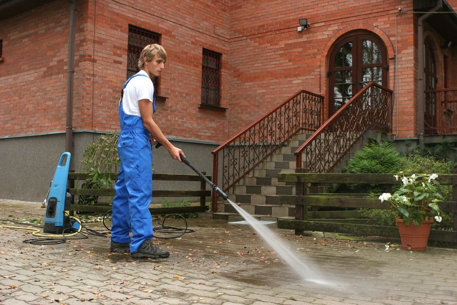 professional cleaning the walkways using pressure washer