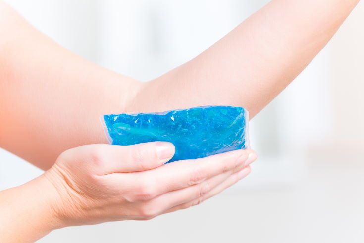 Using cold gel compress on elbow to reduce pain