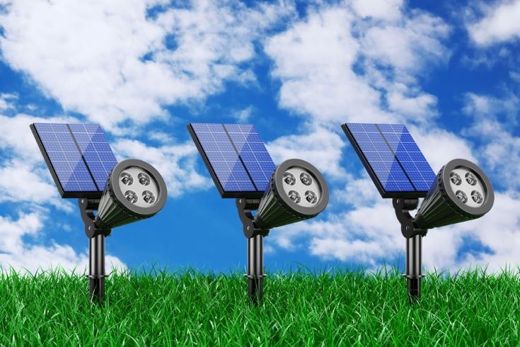 Outdoor Garden LED Spotlights with Solar Panel in Grass on a blue sky background
