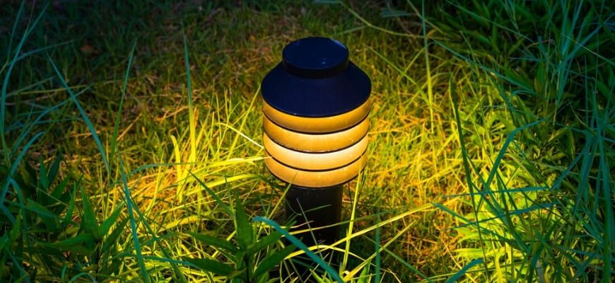 Lighted solar light mounted to ground.