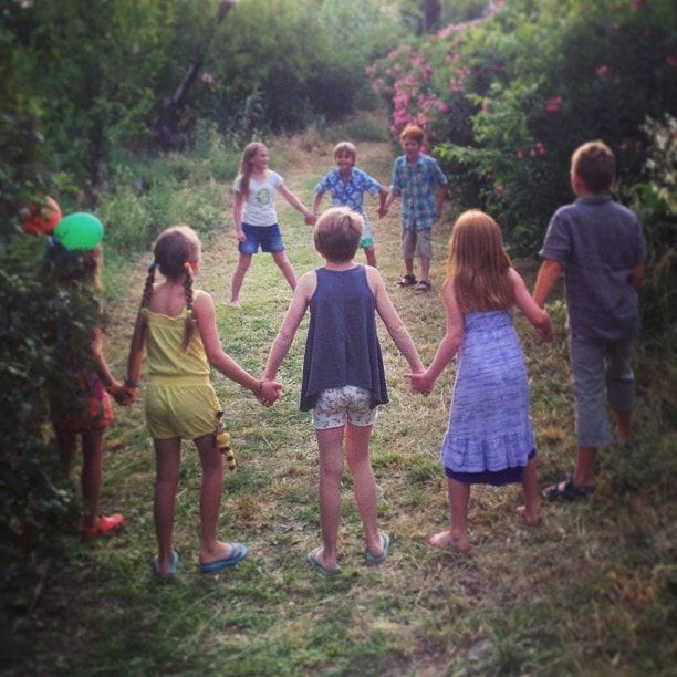 children in a circle playing red rover outdoors in clearing