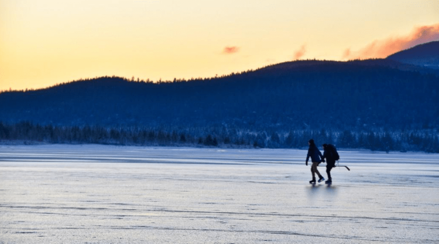 ice skating with hockey sticks on frozen lake in the morning