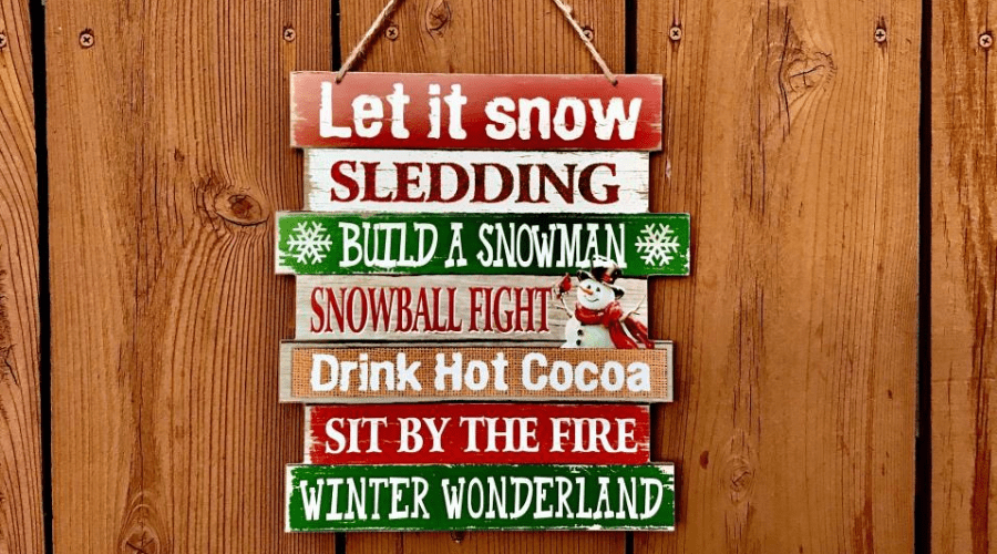 wooden sign for christmas against wood paneled surface