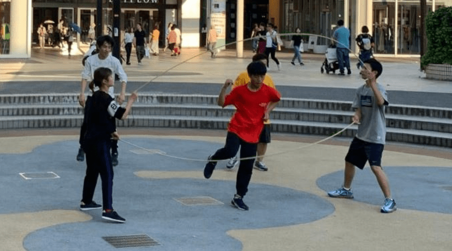 teens playing double dutch in a public park