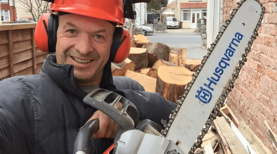 best chainsaw husqvarna man holding new saw in front of a pile of wood