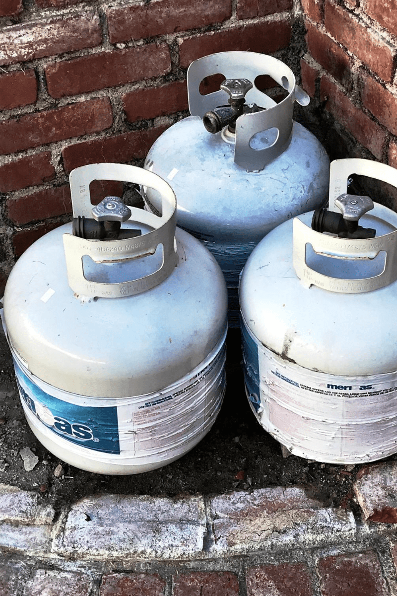 propane tanks stored in the brick fire pit for winter