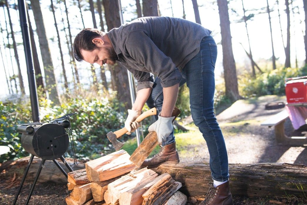 a man cutting firewood into smaller kindling