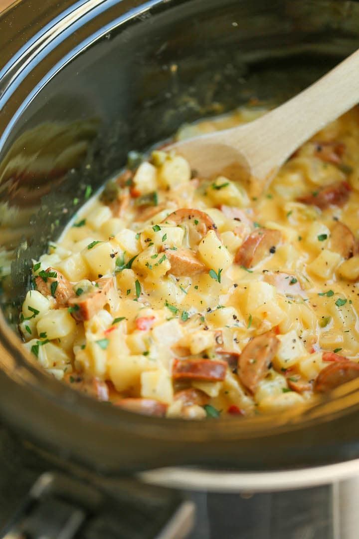 Spoon stirring delicious cheesy breakfast potatoes