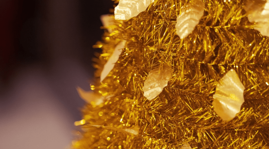 closeup of artificial christmas tree made of gold tinsel and strung with gold leaf-shaped sequins