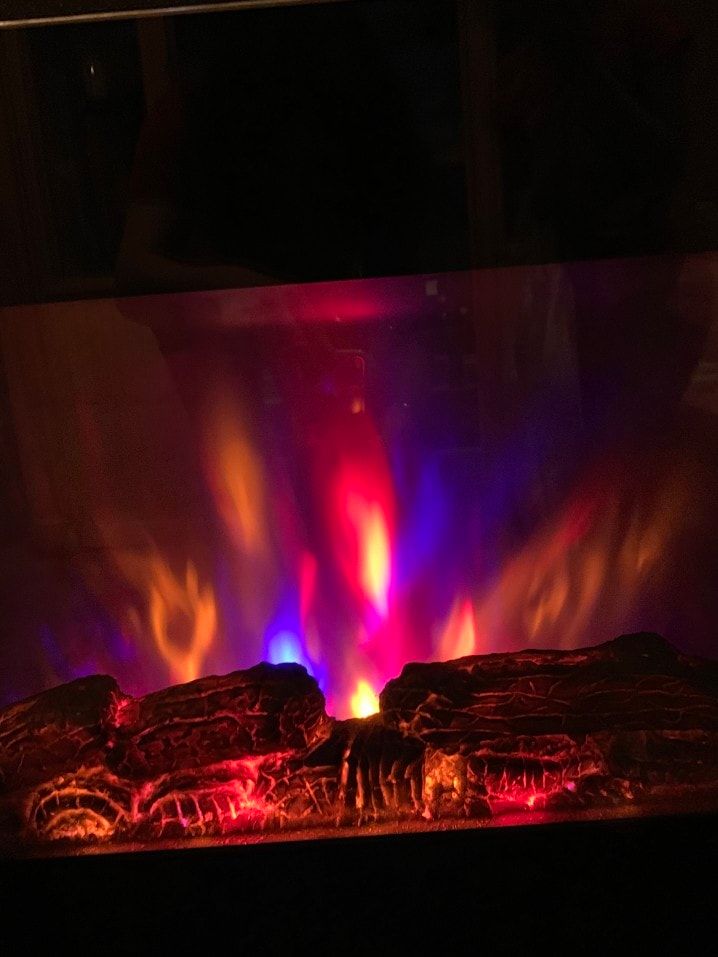 electric fireplace with bright flames in dark room