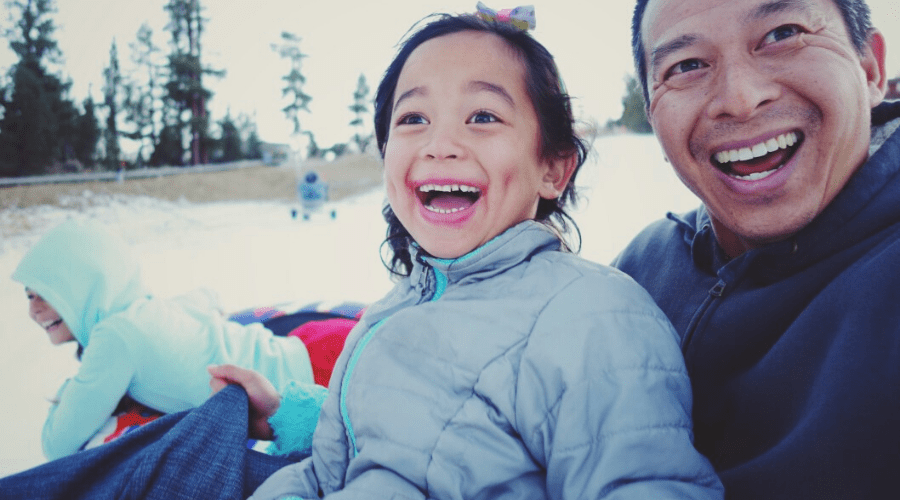 dad daughter selfie while sledding in snow