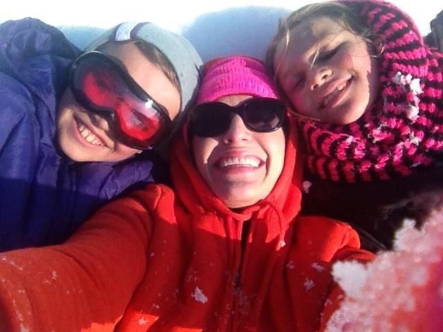 family selfie on sledding hill snow day