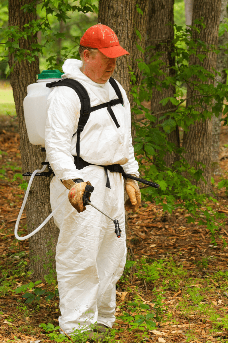 best backpack sprayer tall man in coveralls treats lawn for weeds wearing backpack sprayer