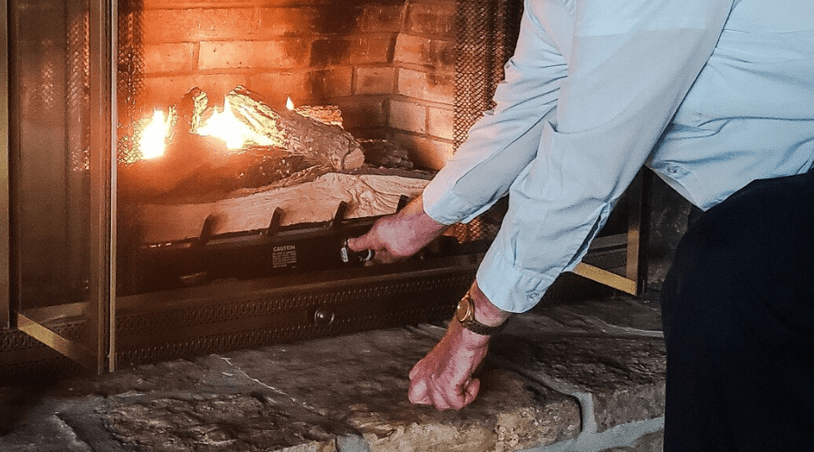 Older man is an active senior who is adjusting his gas logs after turning them on in the winter for warmth and comfort in his home