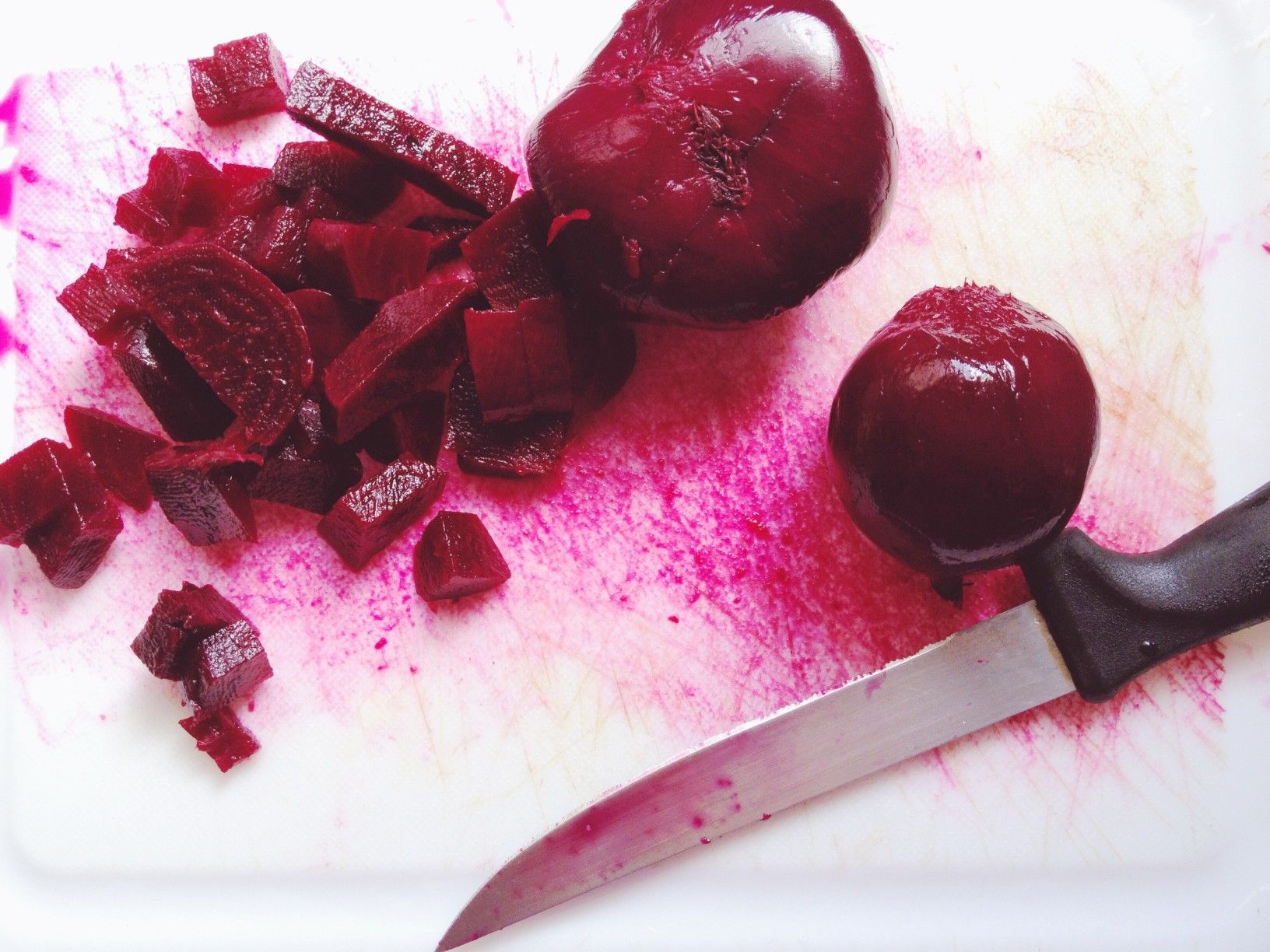 Cooked beet root in a white cutting board with knife beet juice diy ice melt