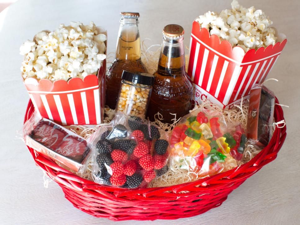 diy movie night basket with soda, popcorn, candy and other goodies for neighbors
