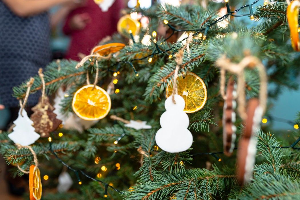 Dried orange slices and a white snowman hanging on a Christmas tree