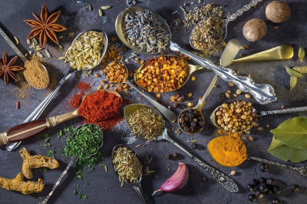 spices and seasonings in spoons on table flatlay