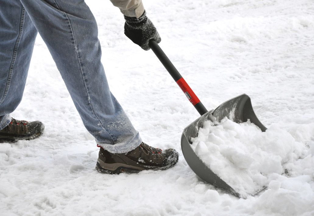 Man shoveling snow in jeans and slip-proof shoes