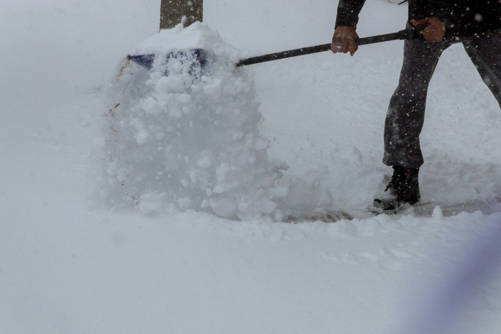 City service cleaning snow winter with shovel after snowstorm yard