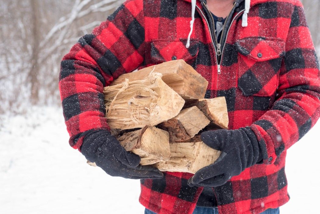 twenty20_man carrying split firewood outdoors in winter