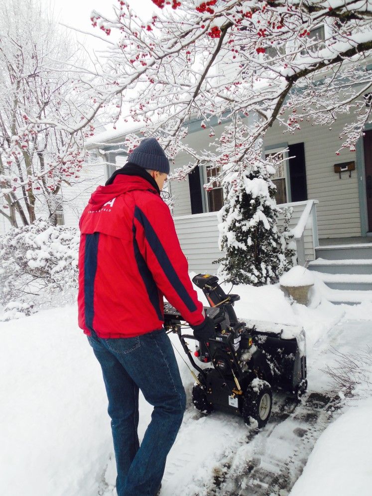 man using snowblower on front sidewalk walkway drive winter