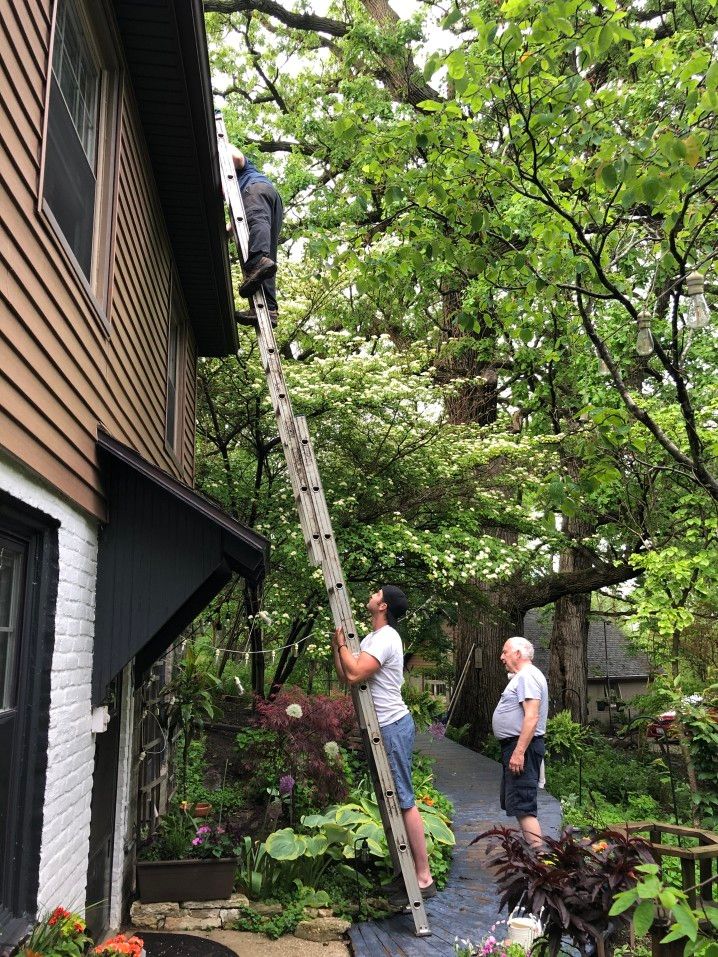 men on ladder cleaning gutters at home