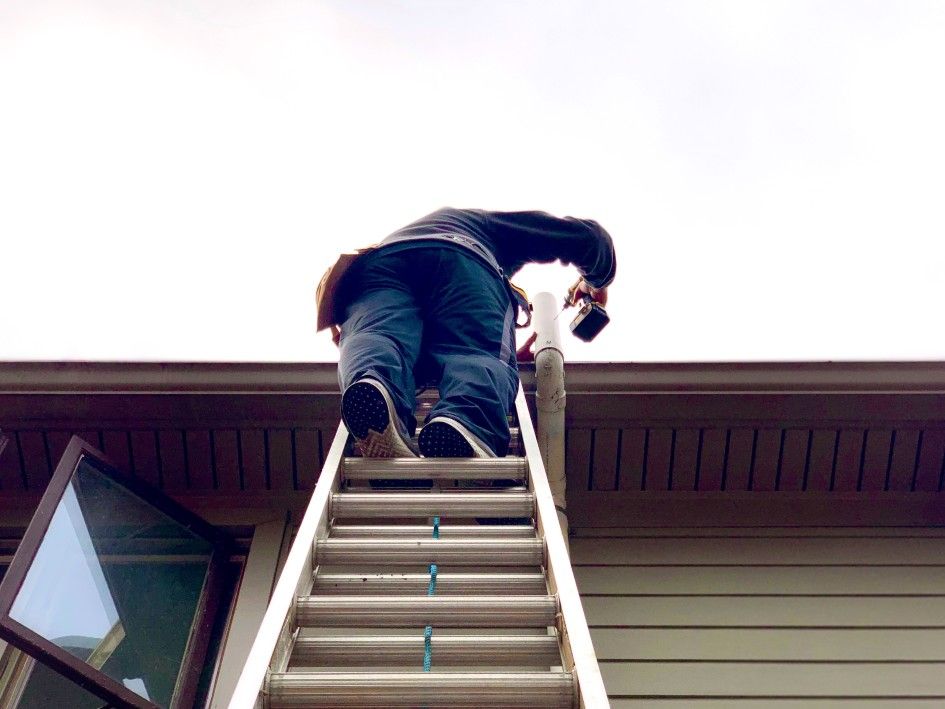 man on ladder to roof