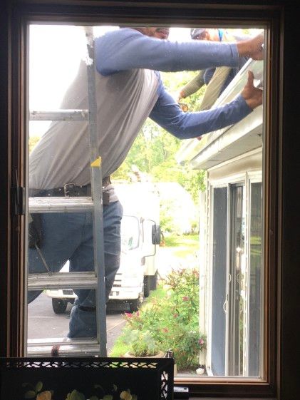 Man on ladder installing new gutters on home, ladder, outdoor, home improvement, installation,
