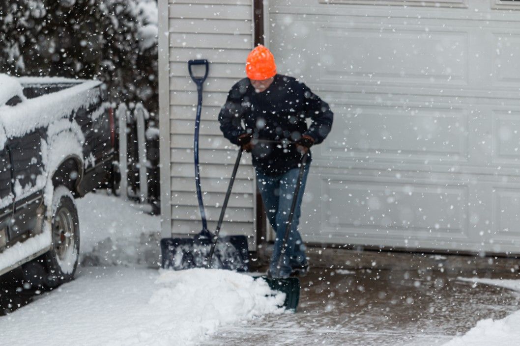 Man shoveling snow off a driveway