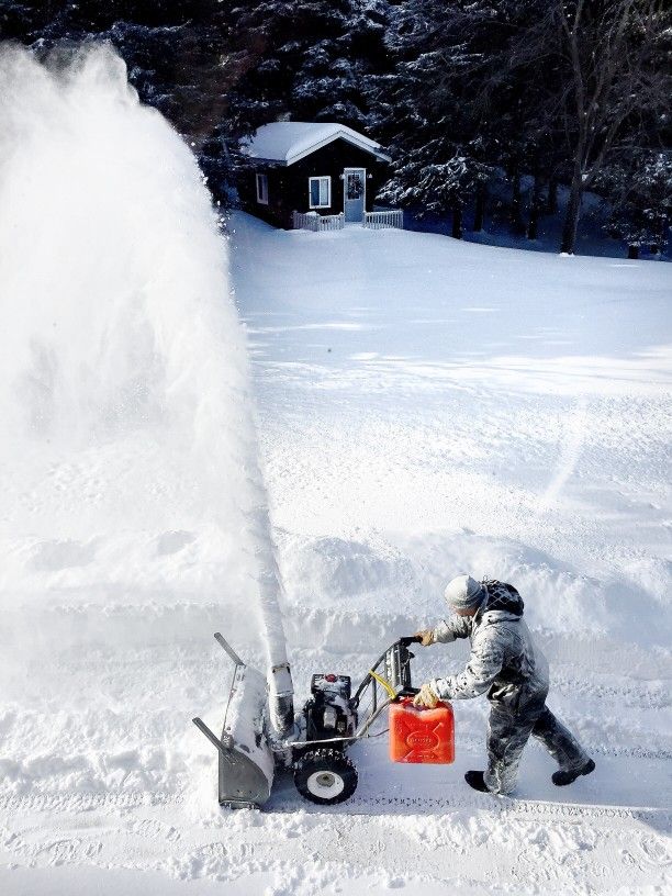man uses snow blower to clear deep snow