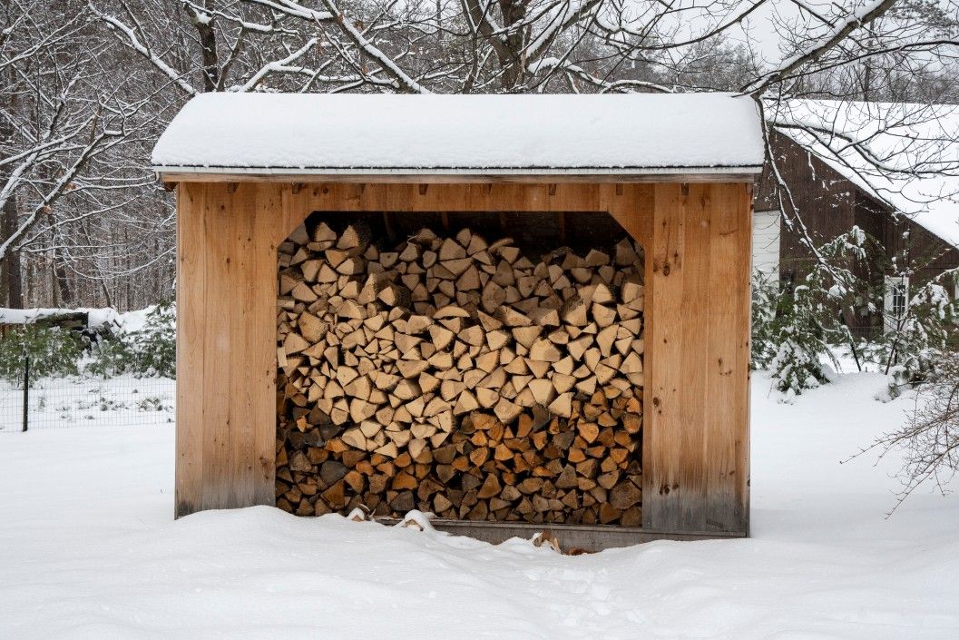 a woodshed in winter with seasoned wood