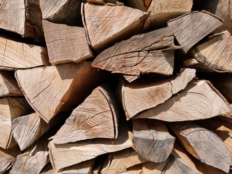 Close up view of dry, split and stacked firewood from the front-full surface